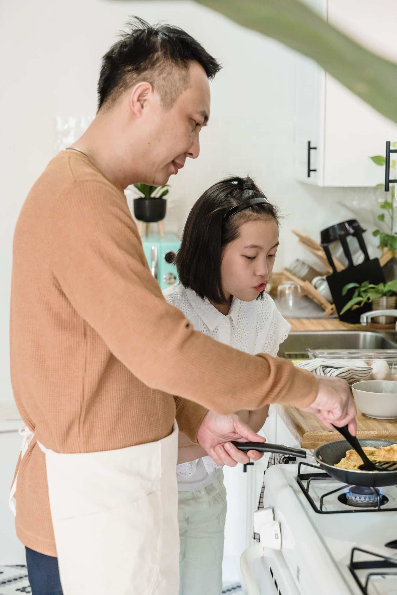 father cooking eggs for daughter