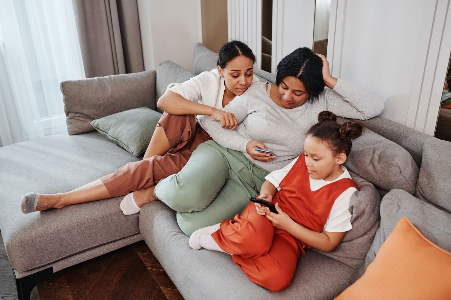mom looking at phone sitting with kids on couch