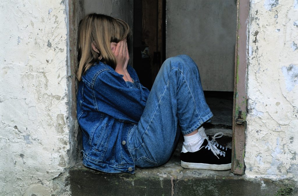 girl cries with face in hands